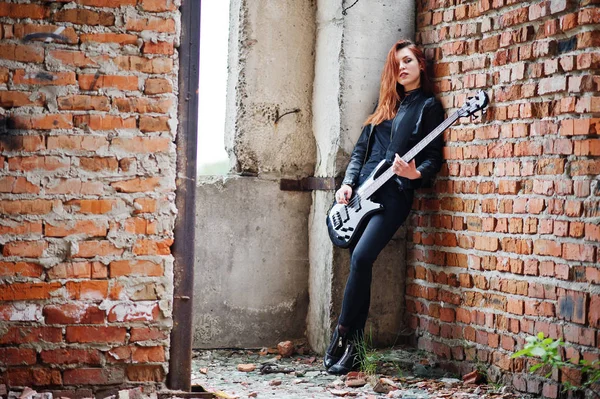 Rojo chica punk pelo desgaste en negro con bajo guitarra en abadoned —  Fotos de Stock
