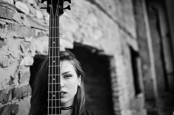 Rojo chica punk pelo desgaste en negro con bajo guitarra en abadoned —  Fotos de Stock