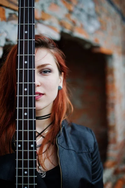 Rojo chica punk pelo desgaste en negro con bajo guitarra en abadoned —  Fotos de Stock