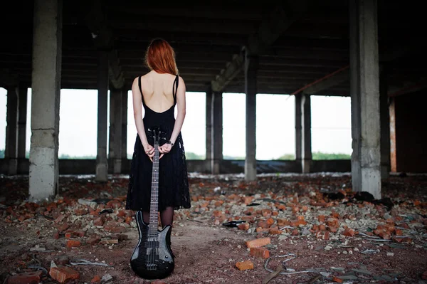 Rouge chevelu punk girl porter sur noir avec guitare basse à abadoned — Photo