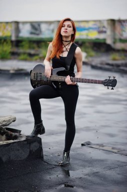 Kırmızı saçlı punk kız giyim siyah ile çatı, bas gitar.
