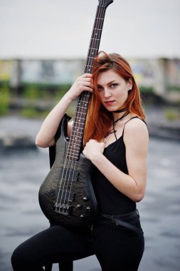 Kırmızı saçlı punk kız giyim siyah ile çatı, bas gitar.