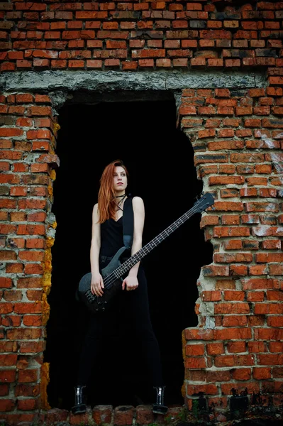 Rojo chica punk pelo desgaste en negro con bajo guitarra en abadoned —  Fotos de Stock