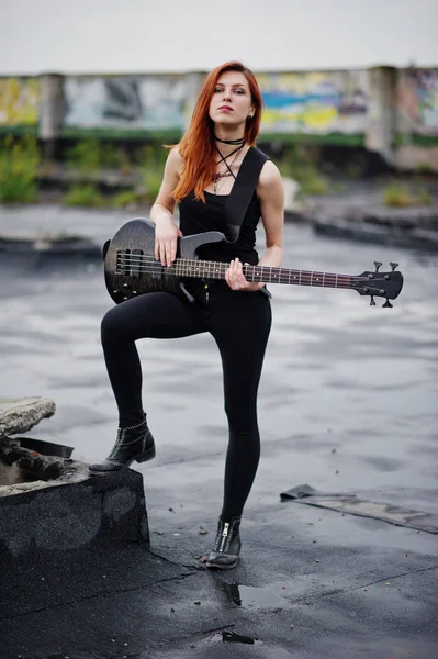 Rojo chica punk pelo desgaste en negro con bajo guitarra en el techo . —  Fotos de Stock