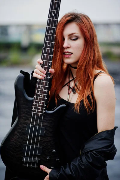 Rosso dai capelli punk ragazza indossare su nero con basso chitarra sul tetto . — Foto Stock