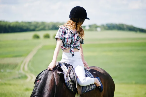 Young pretty girl riding a horse on a field at sunny day. — Stock Photo, Image