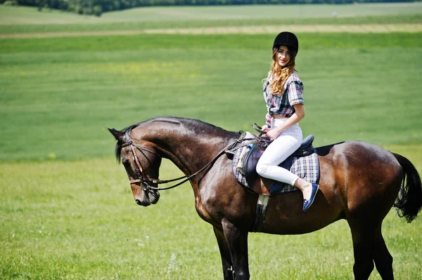 Jeune jolie fille chevauchant un cheval sur un champ à la journée ensoleillée . — Photo