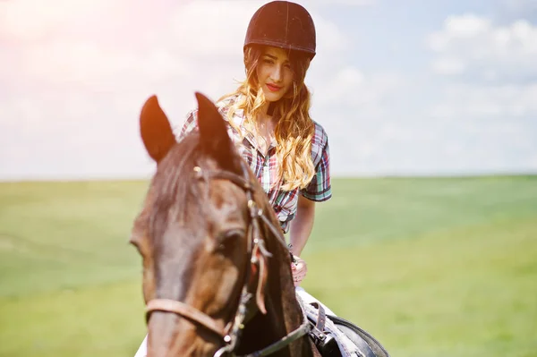 Mooi meisje berijden van een paard op een veld op een zonnige dag. — Stockfoto