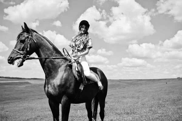 Mooi meisje berijden van een paard op een veld op een zonnige dag. — Stockfoto