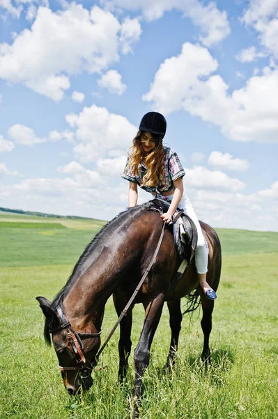 Young pretty girl riding a horse on a field at sunny day. — Stock Photo, Image
