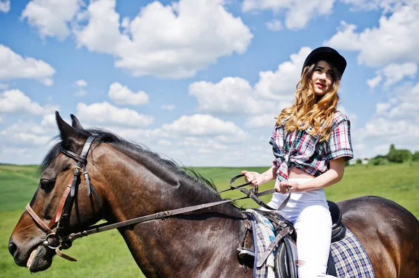 Mooi meisje berijden van een paard op een veld op een zonnige dag. — Stockfoto