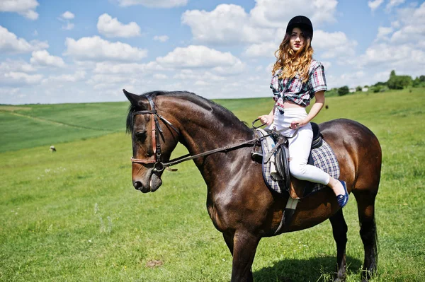 Jeune jolie fille chevauchant un cheval sur un champ à la journée ensoleillée . — Photo