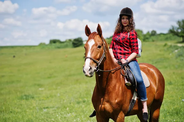 Jeune jolie fille chevauchant un cheval sur un champ à la journée ensoleillée . — Photo