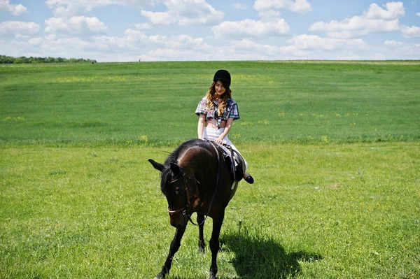 Mooi meisje berijden van een paard op een veld op een zonnige dag. — Stockfoto