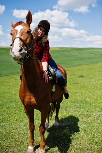 Mooi meisje berijden van een paard op een veld op een zonnige dag. — Stockfoto