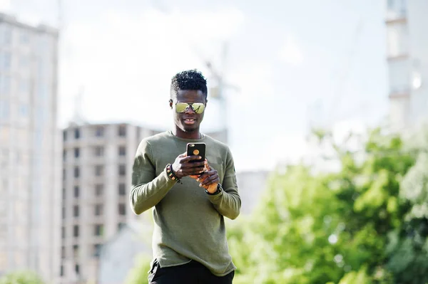 Aantrekkelijke jonge Afro-Amerikaanse man dragen van een zonnebril gebruikt hi — Stockfoto