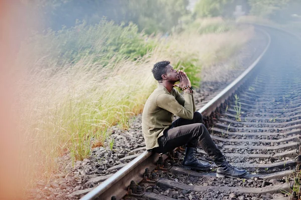 Cool negro africano americano homem sentado e posando na ferrovia em — Fotografia de Stock