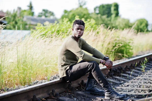 Cool svart afroamerikanska man sitter och poserar på järnväg i — Stockfoto