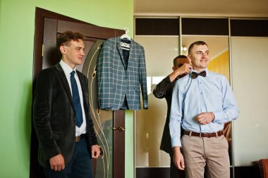 Sağdıçlar odasında onun düğün için hazır olmak için bir damat yardım.