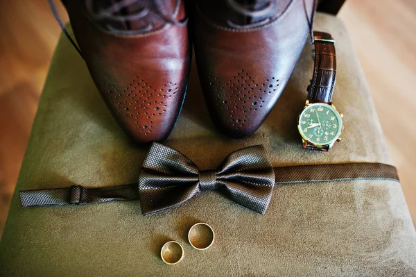 Groom\'s shoes, bow tie, rings and a watch for the wedding ceremo