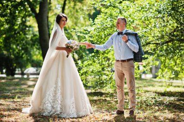 İki çekici genç düğün yürüyor ve park o poz