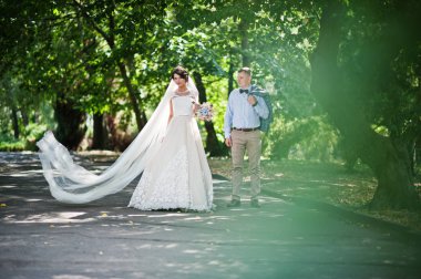 İki çekici genç düğün yürüyor ve park o poz