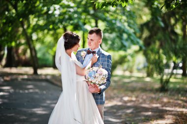 İki çekici genç düğün yürüyor ve park o poz