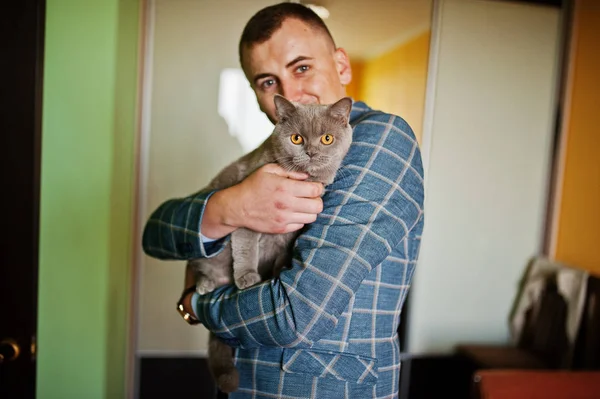 Beau marié posant avec un petit chaton mignon dans sa chambre . — Photo