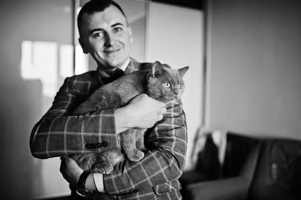 Beau marié posant avec un petit chaton mignon dans sa chambre. Bla ! — Photo