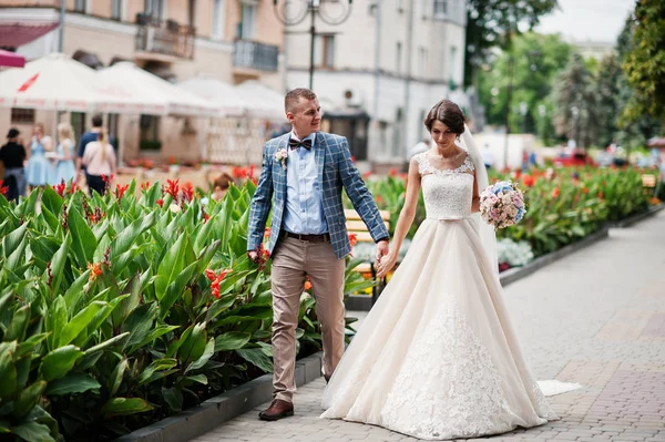 Casamento impecável jovem casal andando nas ruas da cidade em um ensolarado — Fotografia de Stock