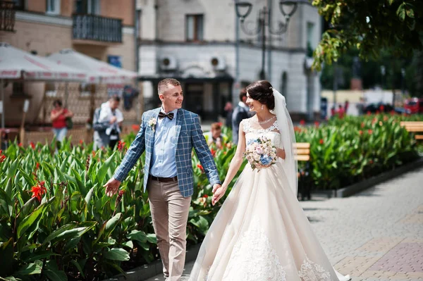 Casamento impecável jovem casal andando nas ruas da cidade em um ensolarado — Fotografia de Stock