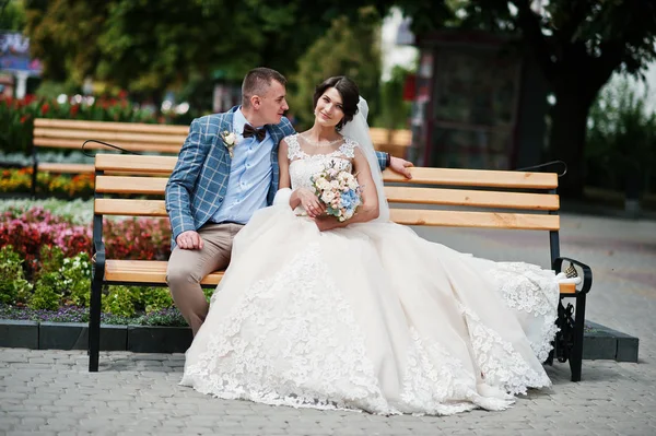Bella coppia di sposi seduti su una panchina nel centro della città o — Foto Stock