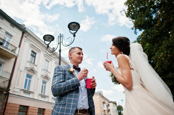 Nygifta dricka drycker i gatan på deras bröllop — Stockfoto