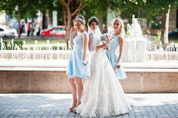 Hermosa novia con damas de honor posando junto a una fuente en th —  Fotos de Stock