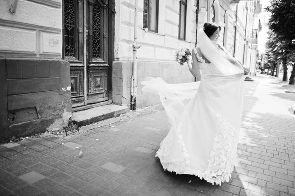 Portret van een eenzame bruid een bloemboeket houden over een stad st — Stockfoto