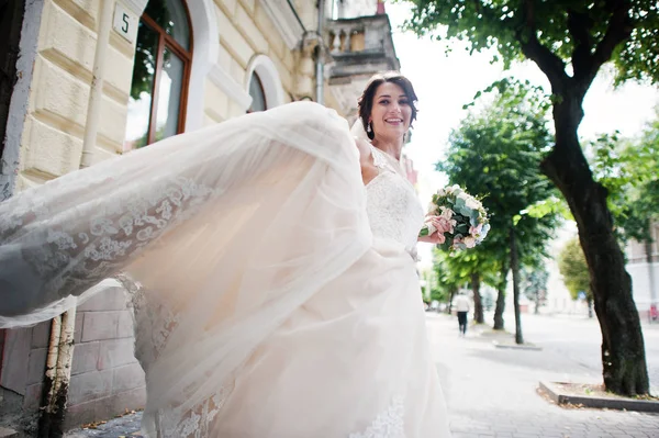 Portrait d'une mariée solitaire tenant un bouquet de fleurs et donnant des coups de pied — Photo