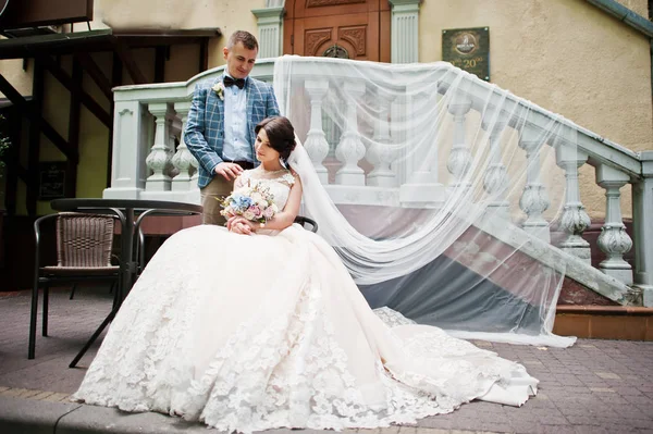 Giovane coppia di nozze splendida seduta accanto al tavolo di vetro con un — Foto Stock