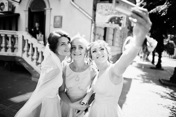 Mariée avec demoiselles d'honneur prenant un selfie dans les rues de la ville. Noir an — Photo