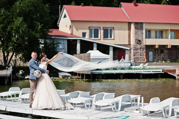 Beau couple marchant sur un quai un jour de mariage ensoleillé . — Photo