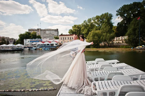 日当たりの良い結婚式の日に埠頭を歩いて美しいカップル. — ストック写真