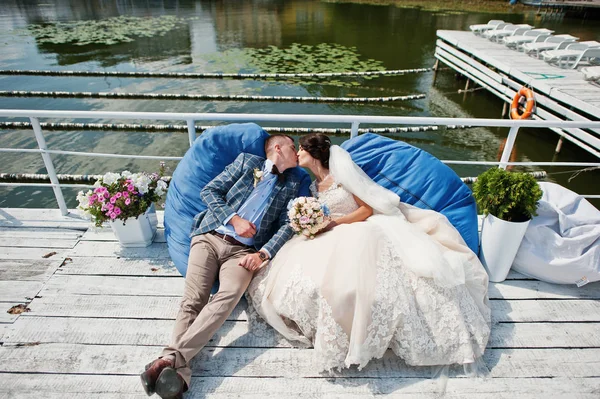 Niesamowitą wyglądające ślubne para siedzi obok jeziora na słońce — Zdjęcie stockowe