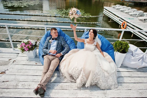 Дивна весільна пара, що сидить біля озера на сонці — стокове фото