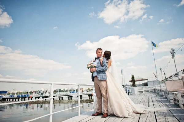 Vackra par går på en wharf på en solig bröllopsdag. — Stockfoto