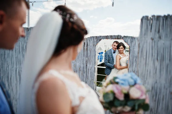 Fantastic bride and handsome groom looking in the mirror on thei — Stock Photo, Image
