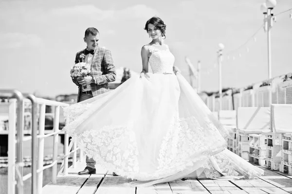 Прекрасная пара, гуляющая по пристани в солнечный свадебный день. Блак — стоковое фото