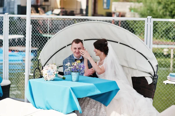 Beautiful wedding couple enjoying each other's comany on a bench — Stock Photo, Image