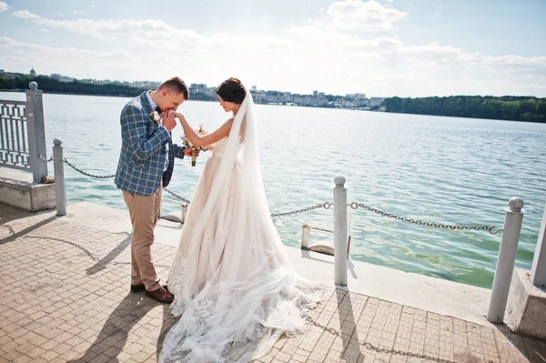 Impresionante pareja de boda caminando junto al lago en un día soleado . —  Fotos de Stock