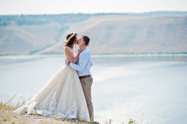 Güzel gelin ve damat öpüşme ile kayalık uçurum kenarında bir
