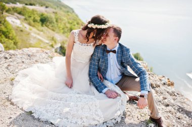 W uçurumun kenarında oturan genç Düğün çifti çarpıcı