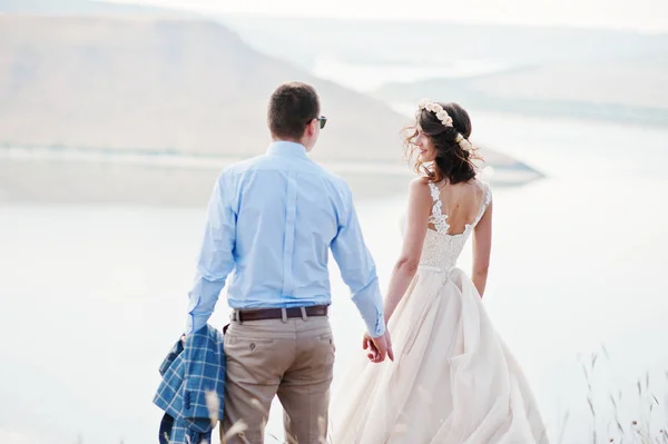 Fantastic wedding couple standing on the edge of rocky precipice